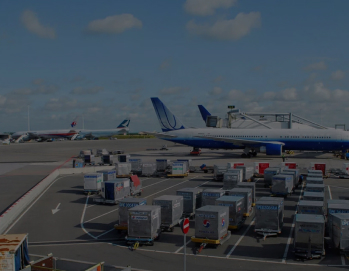 Аэропорт с грузовыми контейнерами на земле и самолетами на взлетно-посадочной полосе под голубым небом